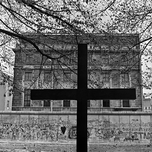 Cruz frente al muro en Berlín occidental