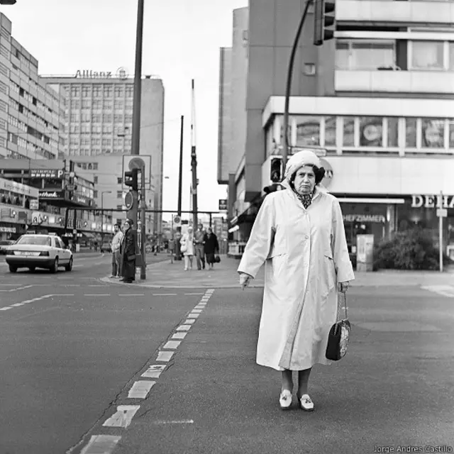 Señora cruza la calle en Berlín occidental