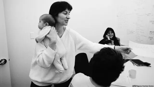 La programadora Sarah Clark trabajando en su oficina en Apple con su bebé en brazos