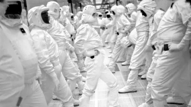 Trabajadores en una fábrica de chips de Intel usando trajes protectores