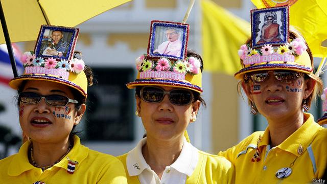 Женщины в шляпах с портретом таиландского короля