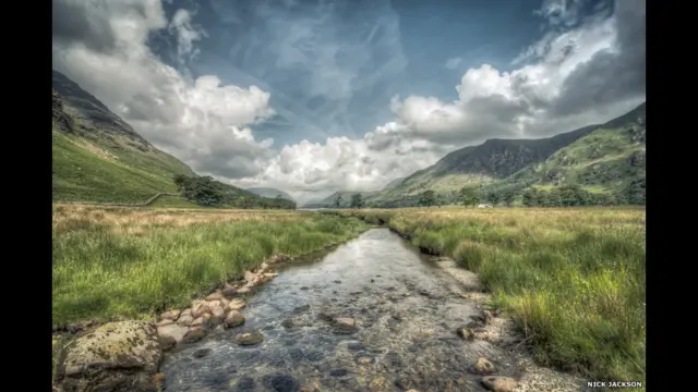 دا د بټرمیر نومې جهیل عکس دی. عکاس نیک جانسن وايي: "په دې منظره کې هر څه سم وو، د غرونو دپاسه له وریځو نیولې تر کوچني کوره او وړې ویالې".