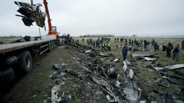 Dutch investigators and an Emergencies Ministry member work at the site where the downed Malaysia Airlines flight MH17 crashed, near the village of Hrabove (Grabovo) in Donetsk region, eastern Ukraine November 16, 2014. 荷兰清理人员在坠机现场清理残骸。 