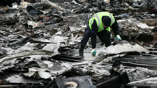 Dutch investigators and an Emergencies Ministry member work at the site where the downed Malaysia Airlines flight MH17 crashed, near the village of Hrabove (Grabovo) in Donetsk region, eastern Ukraine November 16, 2014. 荷兰清理人员在坠机现场清理残骸。