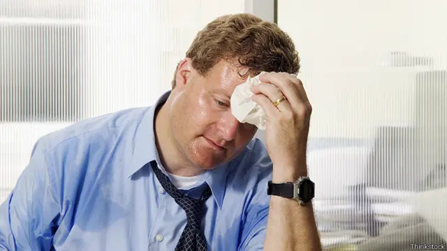 Американский работник вытирает пот со лба