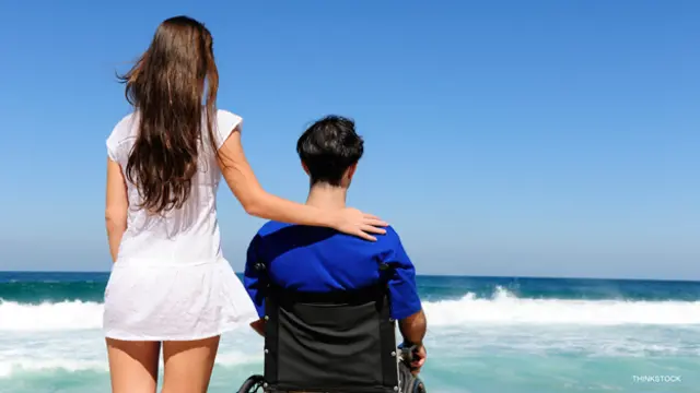 Mujer junto a un hombre en silla de ruedas