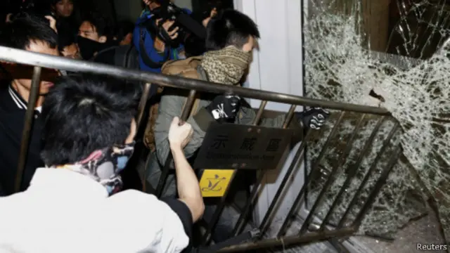 部分戴面具的抗议人士冲击香港立法会大楼。