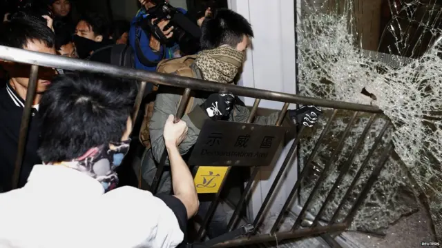 蒙面示威者用鐵馬砸破香港立法會大樓的玻璃門（19/11/2014）