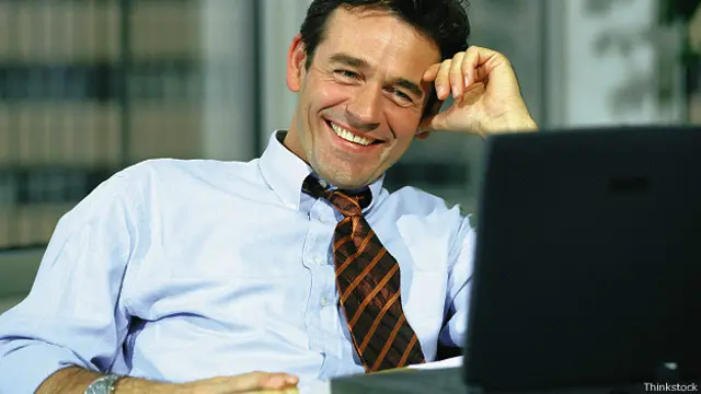 Улыбающийся бизнесмен за компьютером