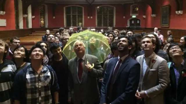 彭定康撑起雨伞。