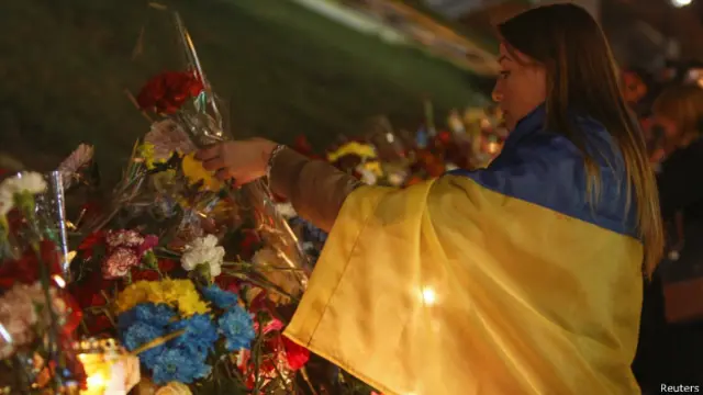 مردم در محل کشته شدن معترضانی که ۲۱ نوامبر سال گذشته در میدان استقلال کشته شدند گل می گذارند