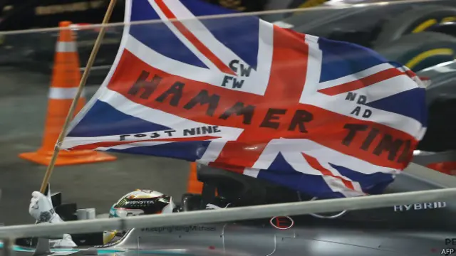 Memasuki garis akhir, Hamilton mengibarkan bendera Inggris dalam kegirangan.