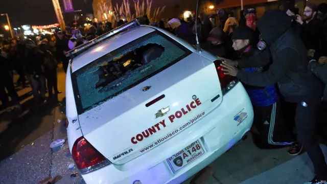 مظاہرین نے پولیس کی گاڑیوں اور مقامی دکانوں کو توڑ پھوڑ کا نشانہ بنایا اور لوٹ مار کے بعد انھیں آگ لگا دی۔