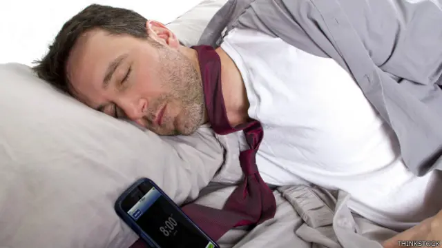 Ejecutivo dormido con su teléfono al lado