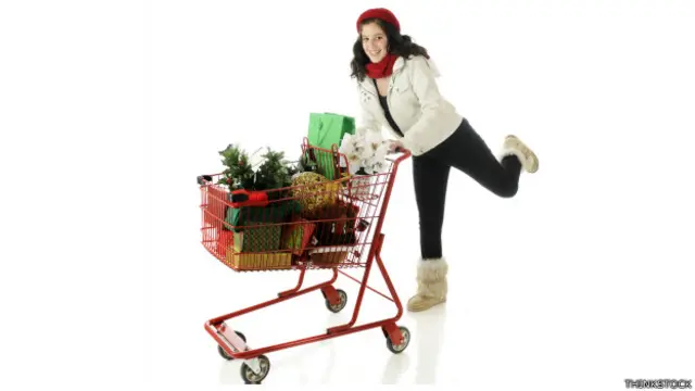 Joven corre con un carrito de compras de navidad