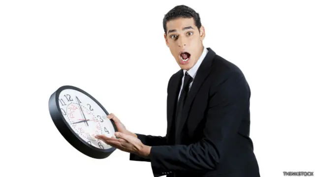 Ejecutivo con un reloj en la mano