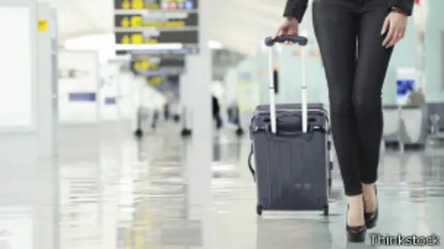 Mujer caminando con maleta en aeropuerto