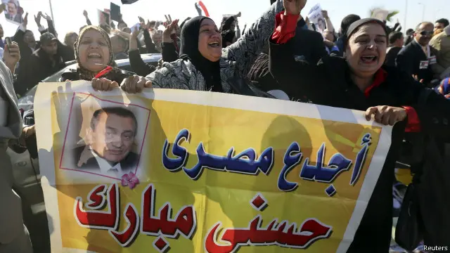 أنصار مبارك يحتفون بالإحكام الصادرة بحقه في محيط قاعة المحكمة في القاهرة. 