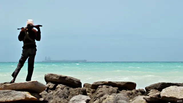 Сомалийский пират, на горизонте захваченный южнокорейский танкер