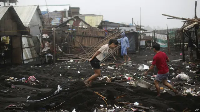 菲律賓黎牙實比市一處海邊村莊村民收拾被颱風黑格比破壞的樓房(8/12/2014)