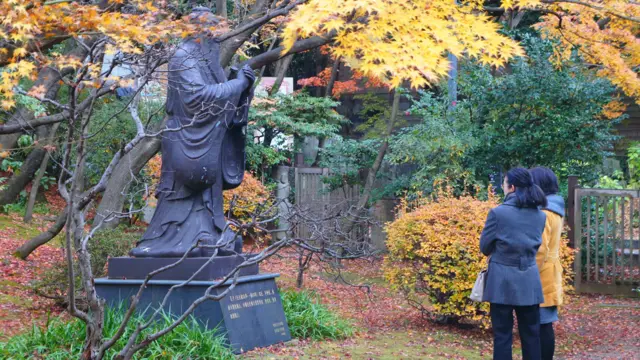 早稻田大學大隈庭園內兩位女士駐足觀看的孔子像（BBC中文網圖片）