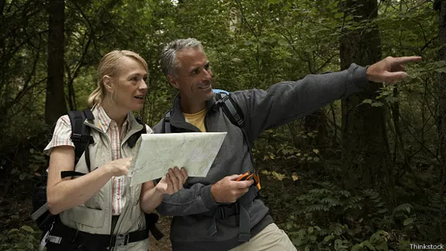 Мужчина и женщина прокладывают маршрут в лесу с помощью карты