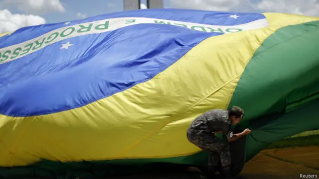 Soldado hasteia bandeira em Brasília (Foto: Reuters)