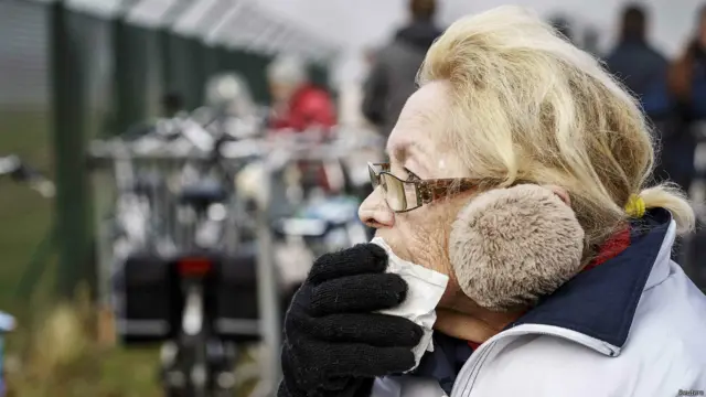 Seorang perempuan menyaksikan kedatangan truk