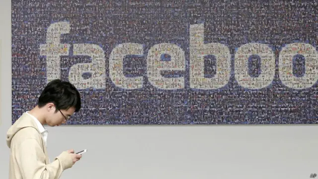 молодой человек на фоне лого "Фейсбука"