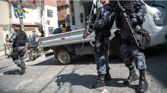 Policías vigilan fuertemente armados en una favela de Brasil.