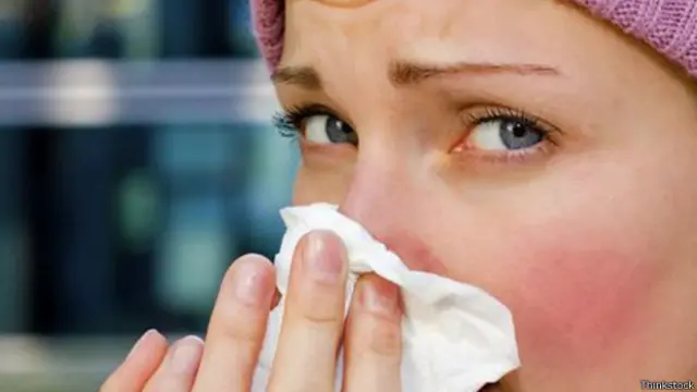 Mujer sonándose la nariz