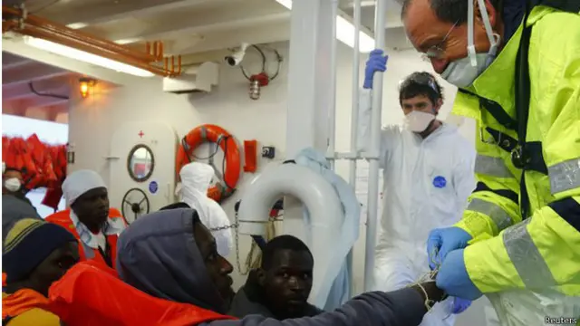 Итальянский врач осматривает спасенных мигрантов.