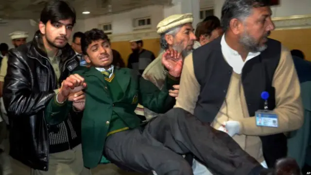 एक घायल छात्र को अस्पातल ले जाते लोग