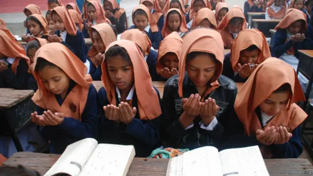 पेशावर के आर्मी स्कूल में मारे गए लोगों के लिए दुआ करती स्कूली लड़कियां