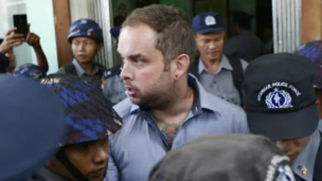 New Zealand citizen Philip Blackwood (C) is escorted by Myanmar policemen after his hearing at a court, Yangon, Myanmar, 18 December 2014.