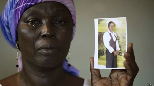 La madre de Monica Mark, una de las jóvenes secuestradas, muestra su foto