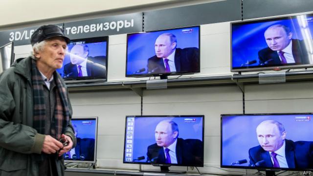 Anciano frente a televisores con Putin