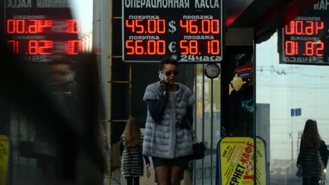 Mujer camina frente casas de cambio