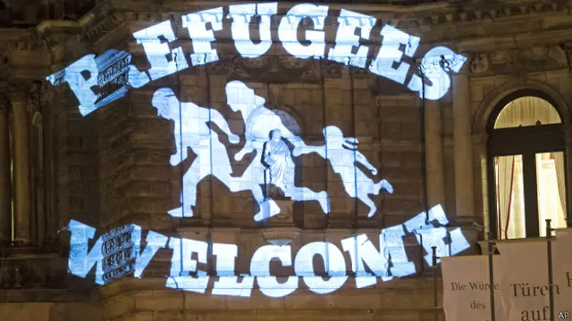 Надпись: "Беженцы, добро пожаловать" проецируется на стену во время митинга в Дрездене