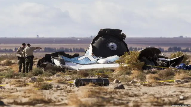 Law enforcement officers take a closer look at the wreckage near the site where a Virgin Galactic space tourism rocket, SpaceShipTwo in Southern California's Mojave Desert