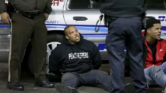 अमरीका में विरोध प्रदर्शन कर रहे काले युवकों को पकड़ती पुलिस