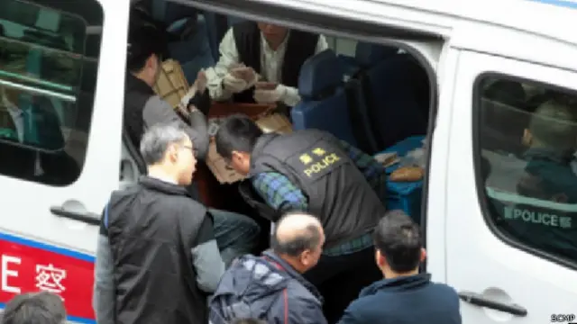 हॉन्गकॉन्ग में पैसे बटोरती पुलिस