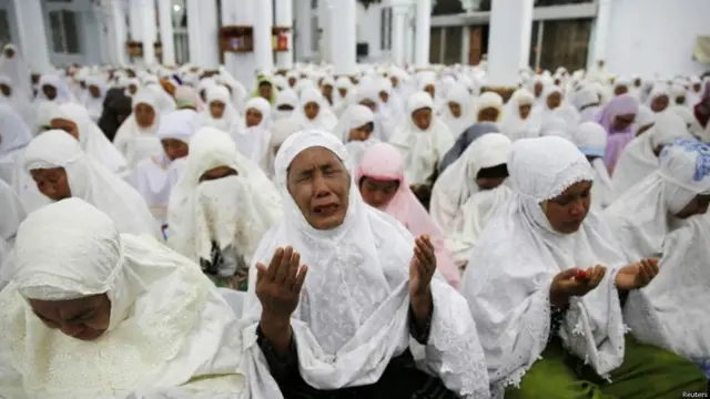 دعاء جماعي في المسجد الكبير بمدينة آتشيه، والذي يعتبر أحد الأبنية القليلة التي صمدت أمام موجات المد.