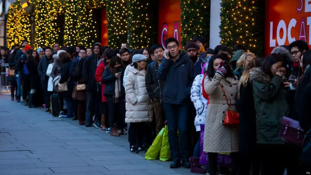 一大清早，天还没全亮，扫货大军就已经在各大百货商场门外排队等候，以便抢到“物美价廉”的商品。