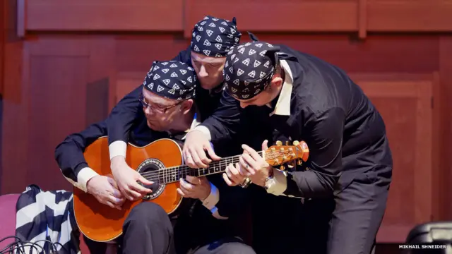 Михаил Шнейдер запечатлел, как уникальное семейное трио "Балкан Стрингс" на концерте в Ульяновске в шесть рук исполняет на гитаре песню "Хава нагила".