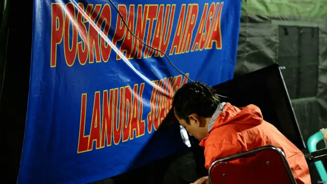 ایک مسافر کا رشتے دار سورابایا کے جواندا ہوائی اڈے پر بنائے گئے ہنگامی مرکز میں کسی خبر کا انتظار کر رہا ہے۔