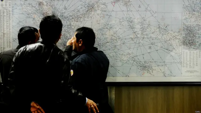 انڈونیشیا کے سرچ اینڈ ریسکیو ادارے کے اہلکار گمشدہ طیارے QZ8501 کی پرواز کے علاقے کے نقشے کا جائزہ لے رہے ہیں۔