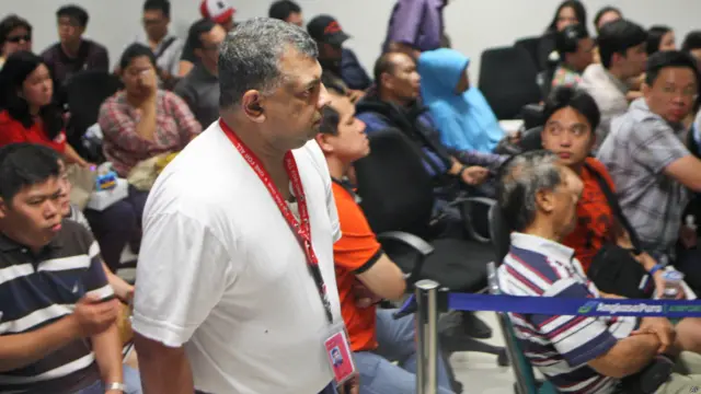 ایئر ایشیا گروپ کے سربراہ ٹونی فرنینڈس جواندا ہوائی اڈے پر مسافروں کے رشتے داروں کے پاس سے گزر رہے ہیں۔