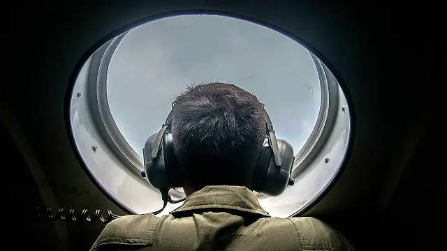 Seorang anggota TNI melakukan pengecekan dari sebuah pesawat untuk mencari keberadaan pesawat AirAsia. 