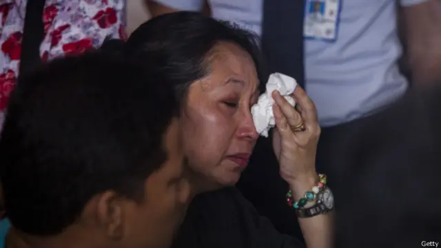 失踪飞机上乘客的亲属难以掩饰悲痛之情